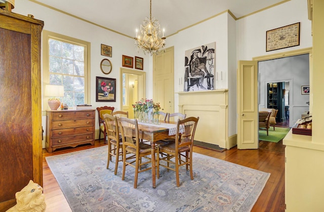 dining room featuring an inviting chandelier, dark hardwood / wood-style floors, and ornamental molding