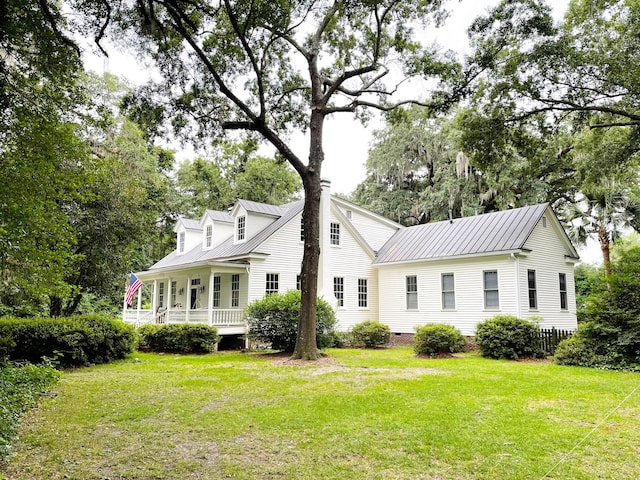 back of property with a porch and a yard