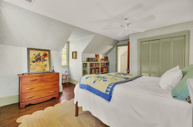 bedroom featuring ceiling fan, a closet, dark wood-type flooring, and lofted ceiling