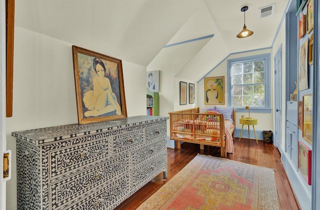 bedroom with wood-type flooring and vaulted ceiling