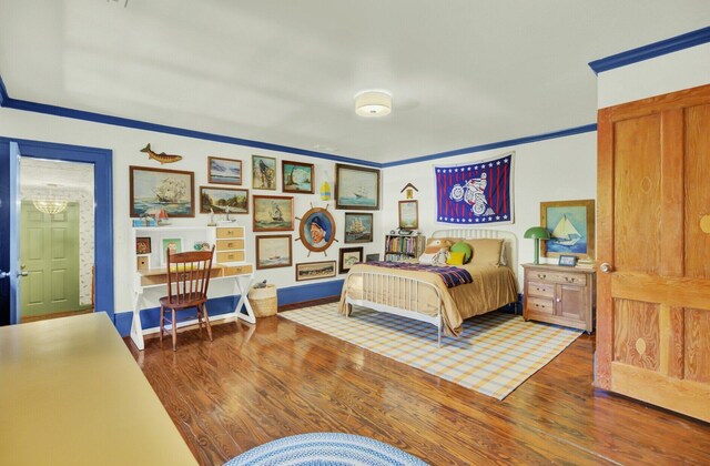 bedroom with dark hardwood / wood-style floors and ornamental molding