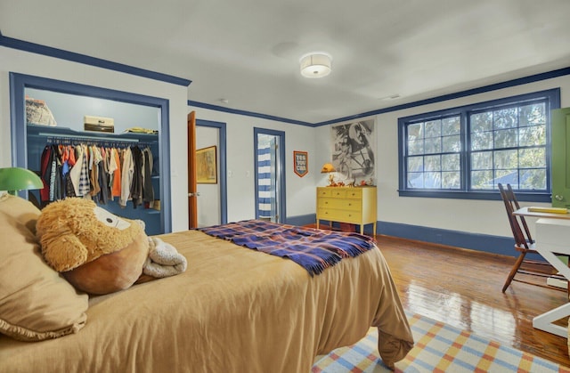 bedroom with hardwood / wood-style flooring, a closet, and crown molding