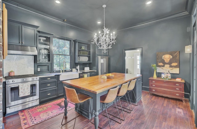 dining space with dark hardwood / wood-style flooring, sink, a chandelier, and ornamental molding