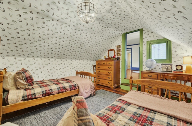 bedroom with hardwood / wood-style floors, baseboard heating, and lofted ceiling