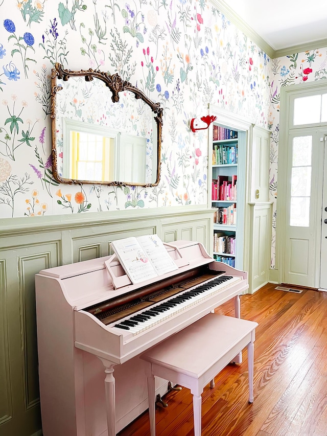 miscellaneous room with crown molding, built in features, and light wood-type flooring