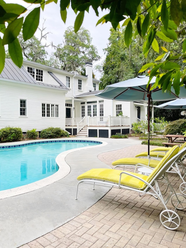 view of swimming pool with a patio and a wooden deck