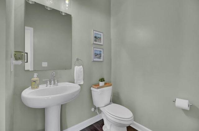 bathroom featuring sink, toilet, and hardwood / wood-style flooring