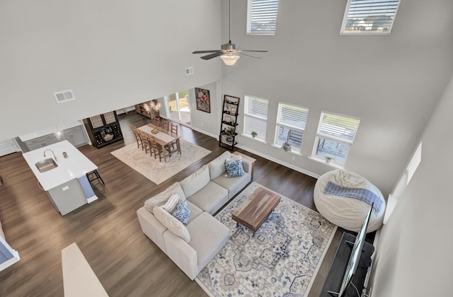 living room with a high ceiling, sink, dark hardwood / wood-style floors, and ceiling fan