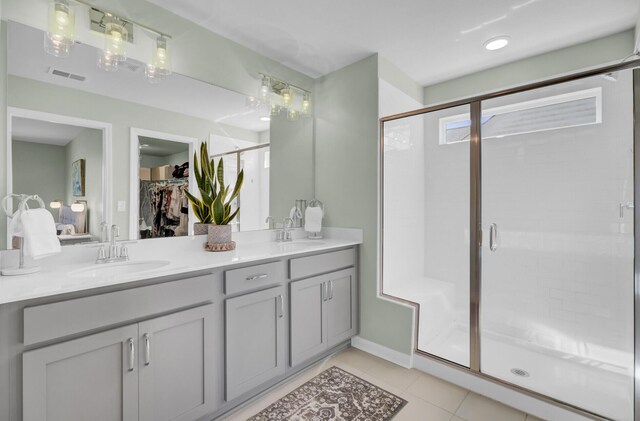 bathroom featuring vanity, a shower with door, and tile patterned floors