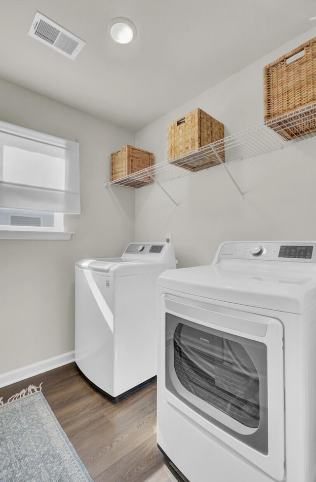 washroom featuring hardwood / wood-style floors and washing machine and clothes dryer