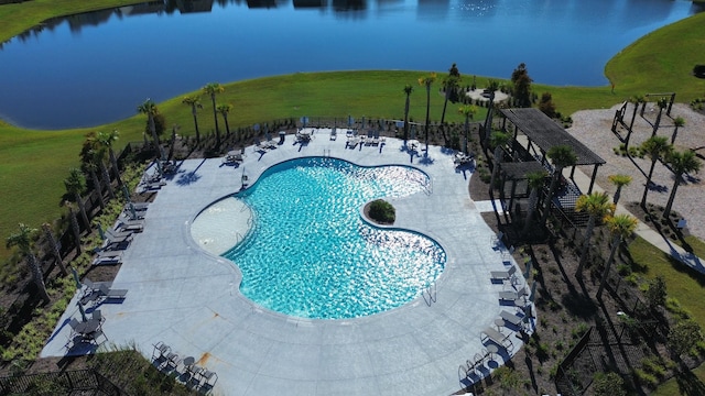 view of swimming pool featuring a water view, a lawn, and a patio area