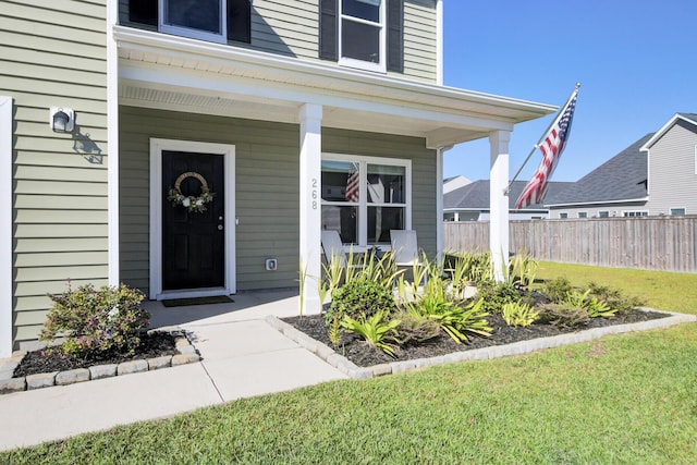 view of exterior entry with a lawn