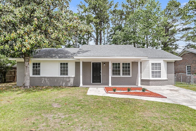 ranch-style house featuring brick siding, a front lawn, and fence