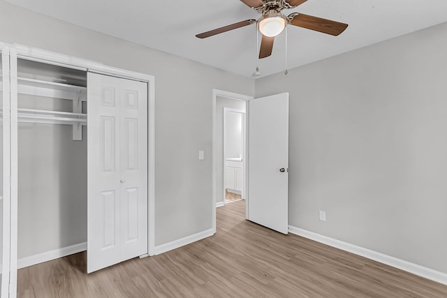 unfurnished bedroom with baseboards, a ceiling fan, wood finished floors, and a closet