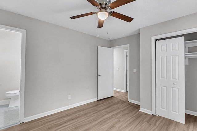 unfurnished bedroom featuring a closet, connected bathroom, light wood-style floors, ceiling fan, and baseboards