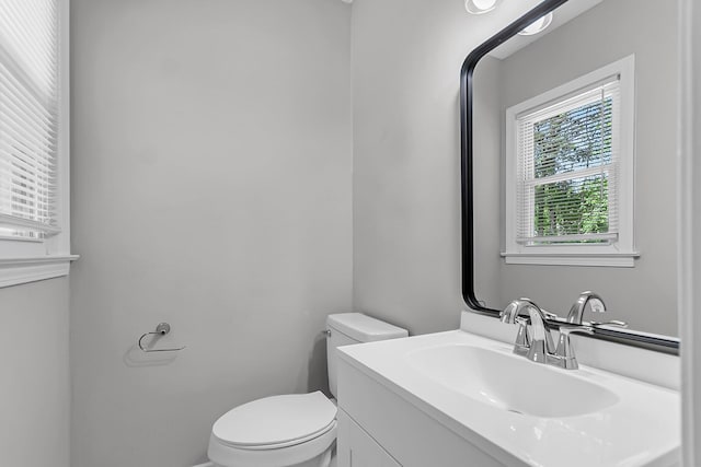 half bath featuring vanity and toilet