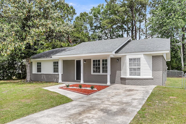 view of front of property with brick siding, driveway, a porch, and a front yard