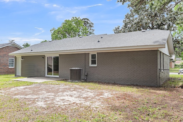 back of house featuring fence, a patio, brick siding, and central AC unit