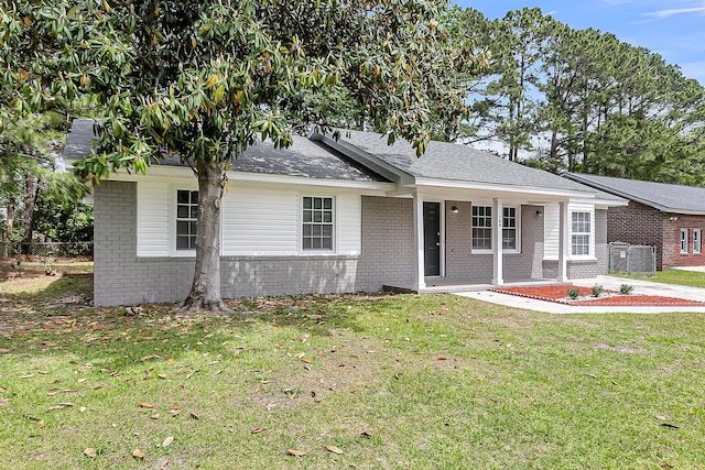 ranch-style house featuring covered porch, a front lawn, and brick siding