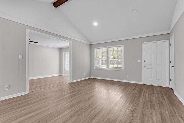 unfurnished living room featuring lofted ceiling with beams, baseboards, and light wood-type flooring