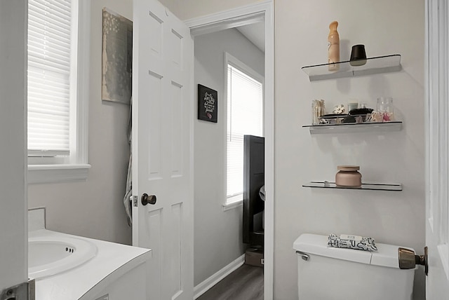 bathroom with wood-type flooring, toilet, and vanity