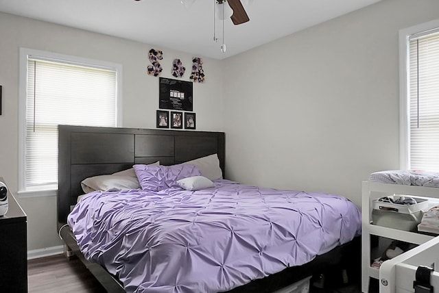 bedroom with wood-type flooring, ceiling fan, and multiple windows