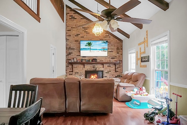 living room with ceiling fan, a fireplace, high vaulted ceiling, hardwood / wood-style floors, and beam ceiling