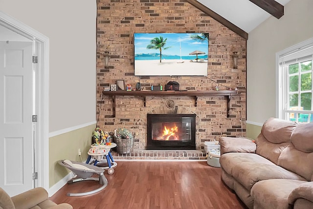 living room with a brick fireplace, vaulted ceiling with beams, and hardwood / wood-style floors