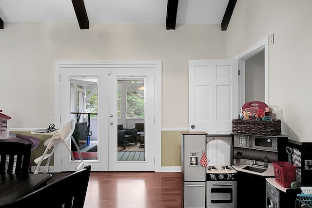 interior space with sink, dark wood-type flooring, beam ceiling, stainless steel oven, and french doors