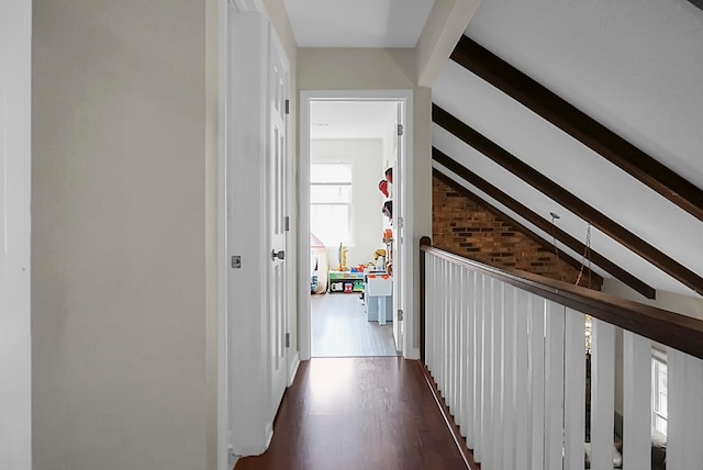 corridor featuring vaulted ceiling with beams, brick wall, and dark wood-type flooring