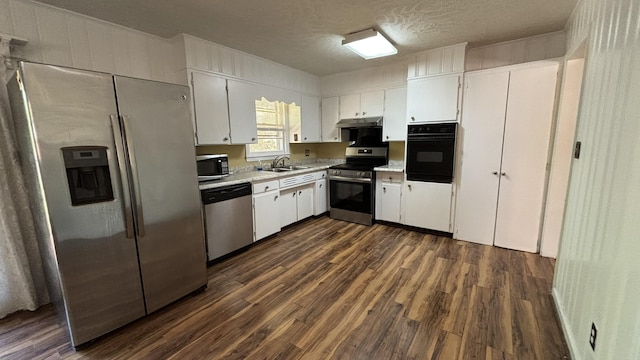 kitchen featuring stainless steel appliances, light countertops, dark wood-style floors, and a sink