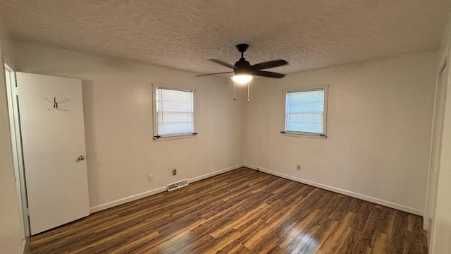 unfurnished bedroom featuring dark wood finished floors, baseboards, and multiple windows