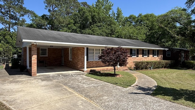 ranch-style home with brick siding, a front lawn, driveway, and an attached carport