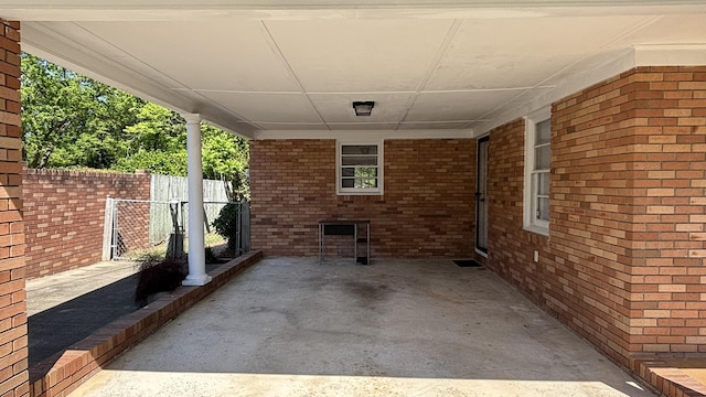 view of patio featuring fence and a carport