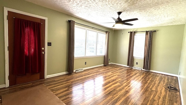 spare room with baseboards, visible vents, wood finished floors, and ceiling fan