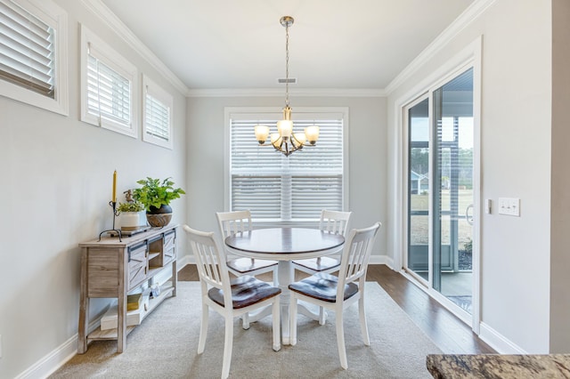 dining room featuring baseboards, wood finished floors, a notable chandelier, and ornamental molding