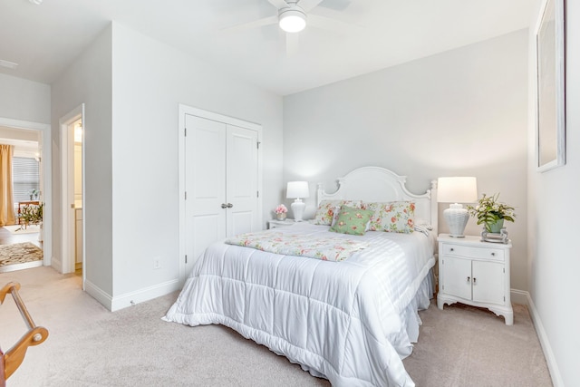 bedroom featuring light colored carpet, baseboards, and a closet