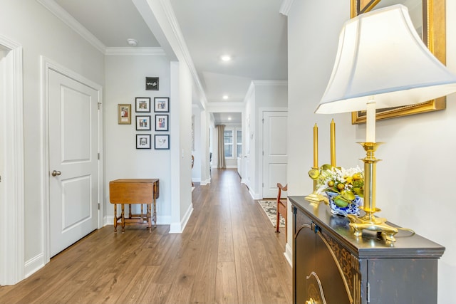 hall featuring recessed lighting, baseboards, wood finished floors, and ornamental molding