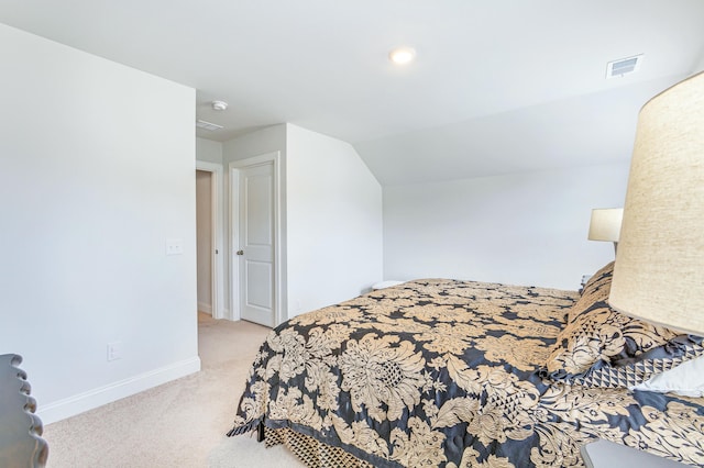 carpeted bedroom with lofted ceiling, baseboards, and visible vents