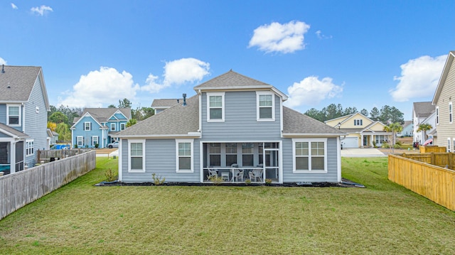 back of house featuring a yard, fence, roof with shingles, and a sunroom