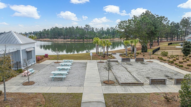 view of patio / terrace featuring a garden, fence, and a water view