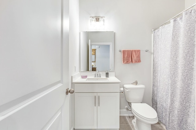 bathroom with vanity, tile patterned floors, toilet, and baseboards