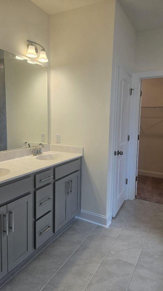 259 Huguenot Trl, Huger, SC 29450 - bathroom featuring double vanity, tile patterned floors, and a walk in closet