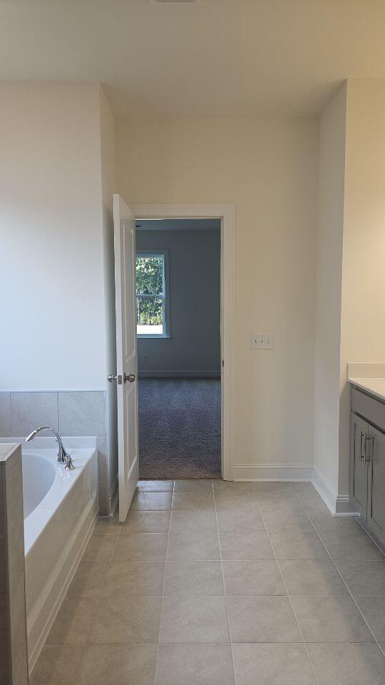 259 Huguenot Trl, Huger, SC 29450 - full bathroom with vanity, a bath, and tile patterned flooring