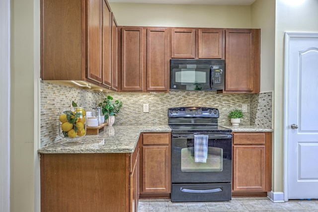 kitchen with backsplash, brown cabinetry, black appliances, and light stone countertops