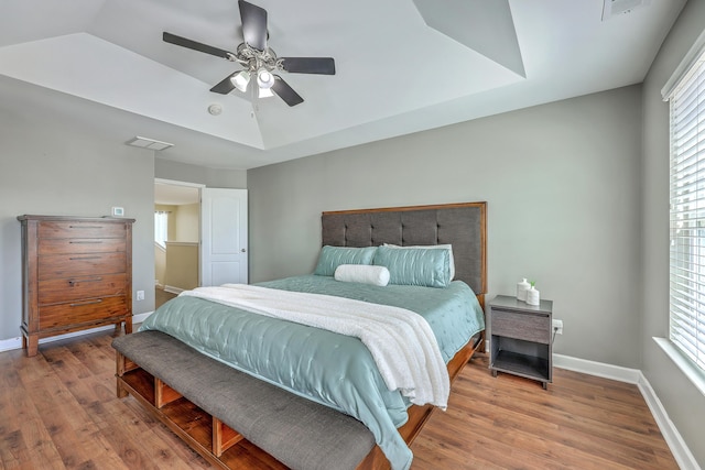 bedroom with wood finished floors, baseboards, a ceiling fan, and visible vents