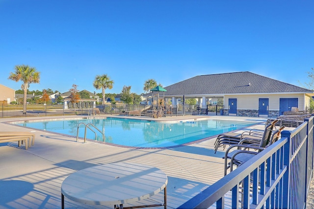community pool featuring fence and a patio