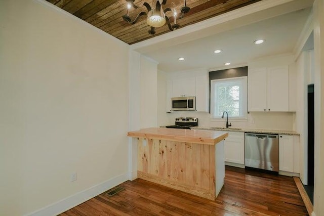 kitchen featuring white cabinets, sink, ornamental molding, dark wood-type flooring, and stainless steel appliances