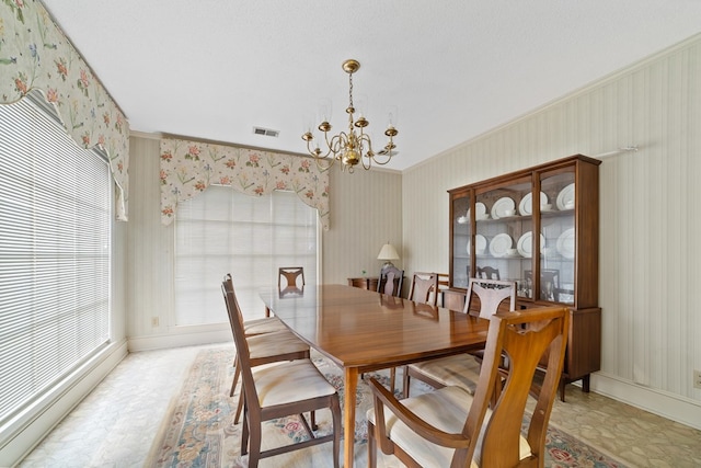 dining area with ornamental molding and an inviting chandelier