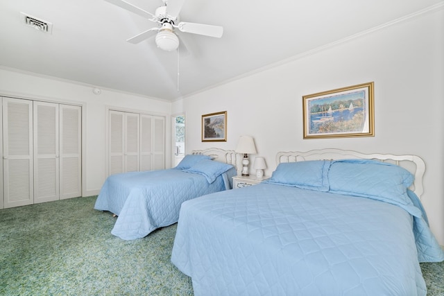 bedroom with carpet floors, ornamental molding, multiple closets, and ceiling fan